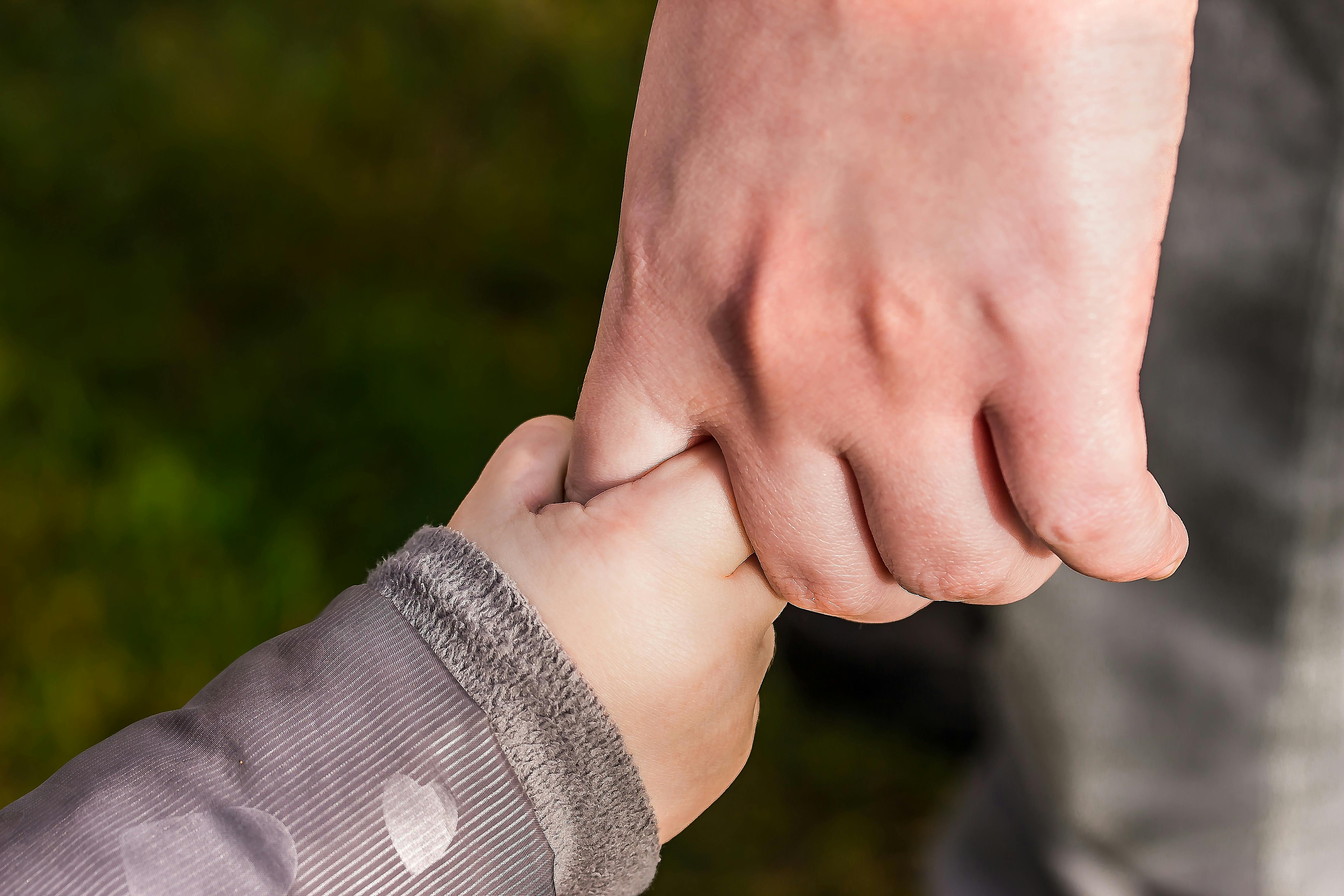 Hand holding child's hand